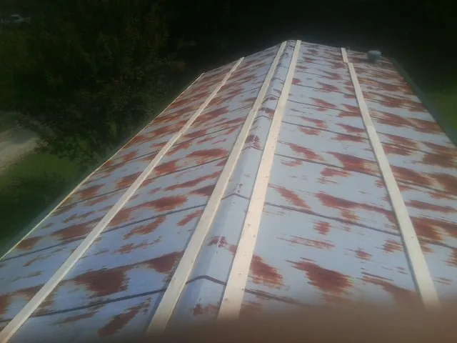 Rusted metal roof panels with new wood purlins before replacement — Storm Damage Roof Repair in Hawaiian Gardens by Roofing Brothers