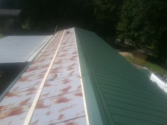 Old rusted panels beside newly installed green metal roofing — Wind Damage Roof Repair by Roofing Brothers in Hawaiian Gardens