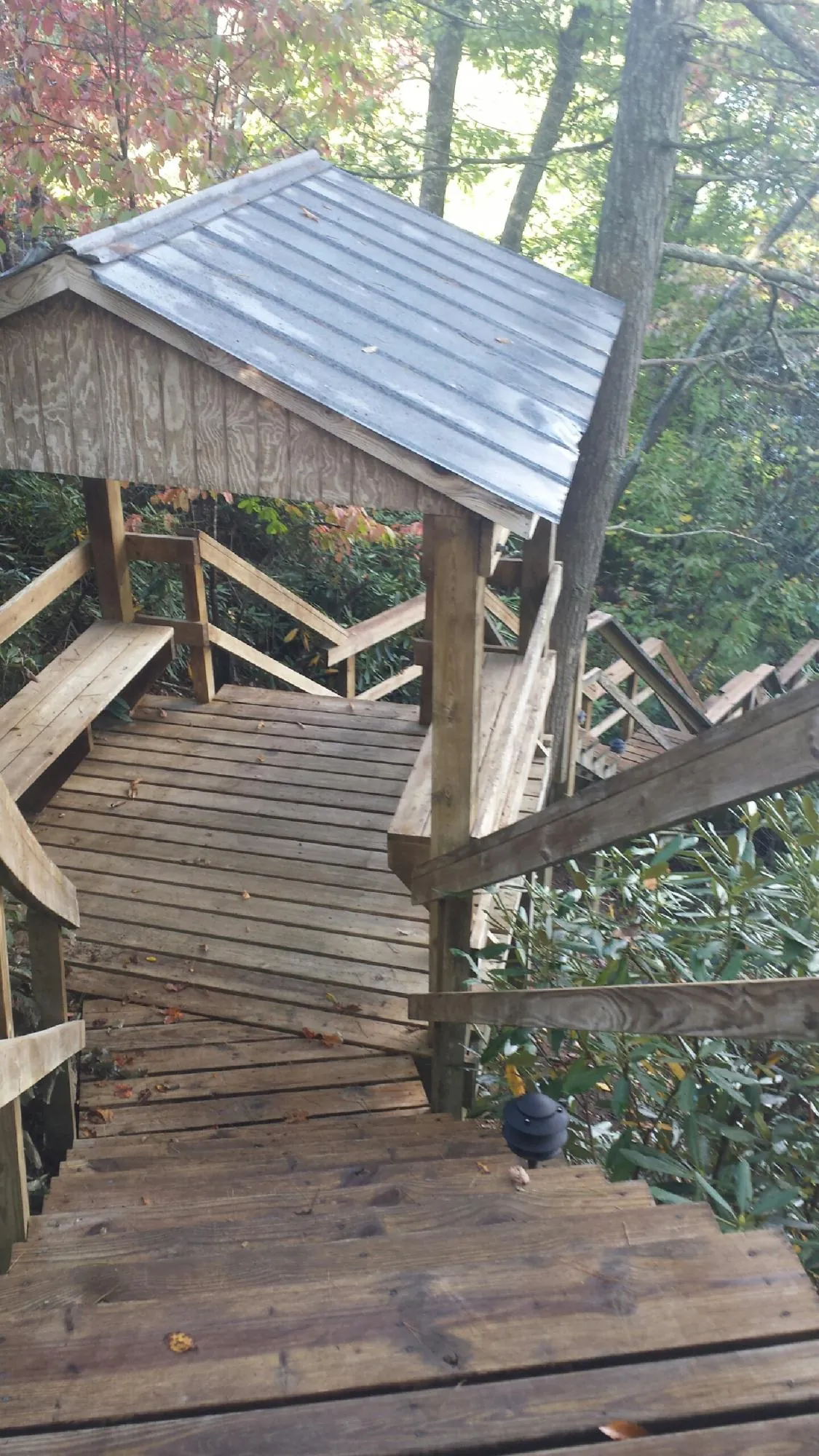 Metal roofed shelter over wooden steps on a wooded walkway — Skylight Repair & Installation work by our crew in Hawaiian Gardens